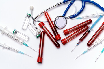 medical ampoule vials, test tubes, syringes and stethoscope over light grey or white background