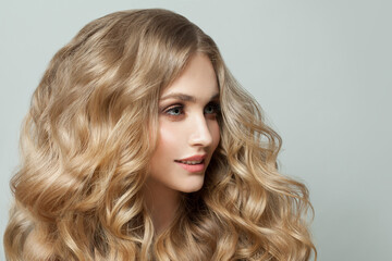 Naklejka premium Beautiful young woman with natural makeup and curly hair close up portrait
