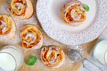 Sweet puff pastry roll for breakfast or snack served with honey and milk. Rolls with crema cheese and peaches. Healthy breakfast or snack for children.