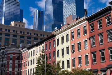 Row of Colorful Old Residential Buildings in Chelsea of New York City with Modern Glass Skyscrapers in Hudson Yards