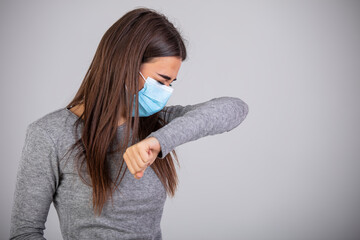 Sick young woman with sterile face mask isolated on gray background. Epidemic pandemic rapidly...