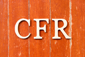 Alphabet letter in word CFR (abbreviation Cost and freight) on old red color wood plate background