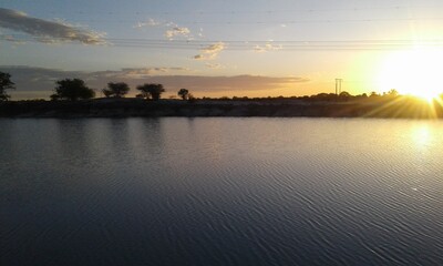 Sunset over a water pan in Oshana region, Namibia.