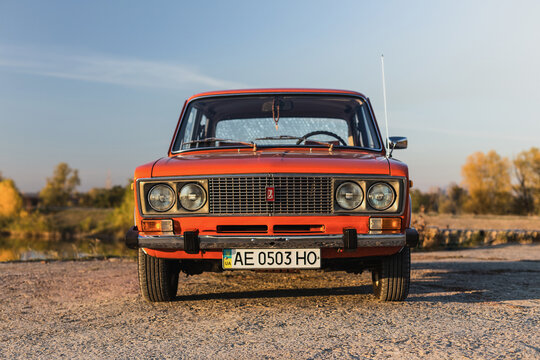 Pereshchepino, Ukraine - October 12, 2014: Zhiguli vaz 2106 original orange, released in the ussr in 70's. car parked near the river, autuman time