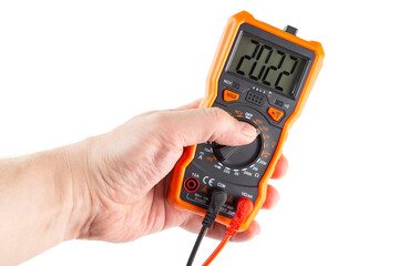 digit 2022 on lcd screen of digital electrical multimeter in left hand, isolated on white background