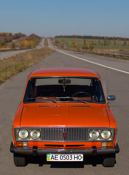 Pereshchepino, Ukraine - October 12, 2014: Zhiguli vaz 2106 original orange, released in the ussr in 70's. car parked on the side of the road in the middle of sunny day without cars nearby