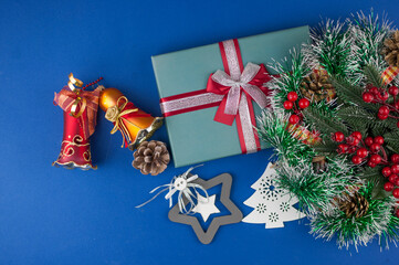 Christmas gift box with decoration on a dark blue  background, top view, copy space.