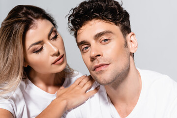  couple in white t-shirts embracing isolated on grey