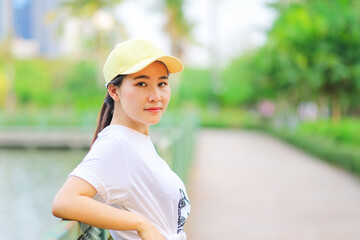 Beautiful Asian woman with yellow cap in public park