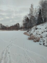 evening landscape by the coastline of a frozen and snowy lake