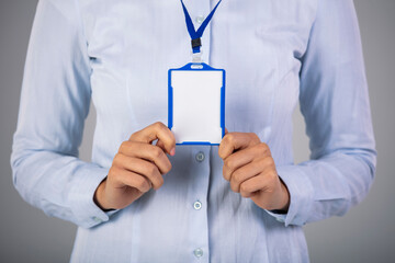 Woman holding Identification white blank plastic id card. Close-up of a blank business card in businesswoman's hand. You can put your text. Blank business card