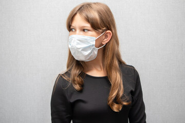 Schoolgirl in medical mask and black dress
