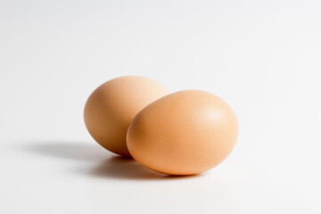 Two brown organic fresh raw eggs. Cut out and isolated on white background with soft shadows for added dimension.