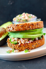 Sandwich with tuna, avocado and vegetables for snack or lunch. Top view with copy space.