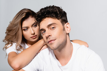  couple in white t-shirts embracing isolated on grey