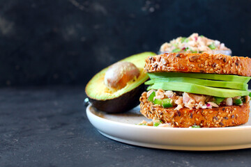 Sandwich with tuna, avocado and vegetables for snack or lunch. Top view with copy space.