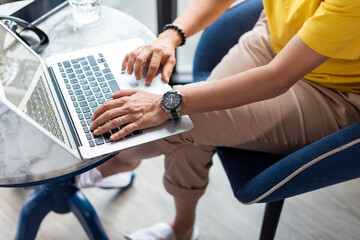 Young woman is typing messages and working on computer at home.