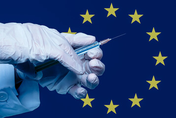 hand with syringe and the inscription sars cov 2 vaccine in front of a european flag