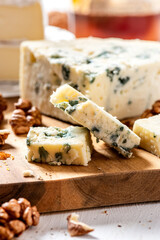 Pieces of gorgonzola close-up. Italian blue cheese gorgonzola on a wooden cutting board.