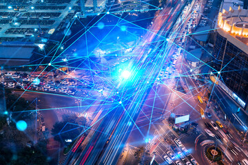 Abstract technology icons hologram on aerial top view of road, busy urban traffic highway at night. Junction network of transportation infrastructure. The concept of hi-tech in logistics.