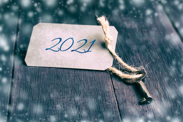 Key with 2021 tag, on a wood background. Christmas background.