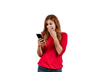 Beautiful young woman in a red sweater, surprised while using on the phone, isolated on a white background.