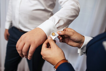Cufflinks wearing background. Dressing up the groom. Wedding preparation background. White shirt for business meeting. Elegance and stylish fashion background.