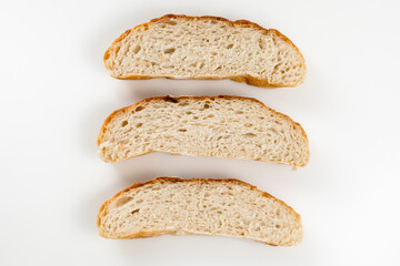 Freshly homemade bread sliced on a white background, light and airy inside with a crunchy rustic crust.