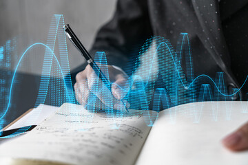 Financial market chart hologram and a woman taking notes. Business education and analysis concept. Multiexposure.