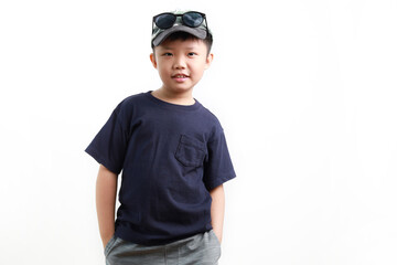 Stylish cute little Asian boy wearing cap and sunglasses posing on white background