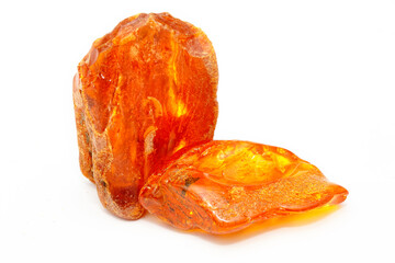 Natural bright polished piece of amber on a white background. Sun stone. Semiprecious mineral. Material for jewelry. Ancient petrified resin. Inclusions in amber. Cracks in the crust. Copal. Fossil