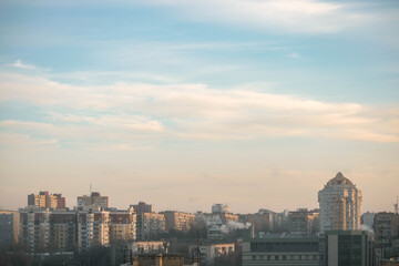 Fototapeta na wymiar City on the background of the cloudy blue sky.