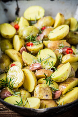 Closeup of baked potatoes with garlic and cherry tomatoes