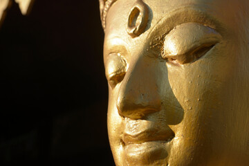 Golden buddha face isolated on black background. Meditation concept.