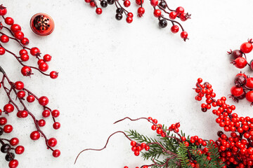 Christmas holidays composition with christmas decorations, red berries branches on white background with copy space, top view