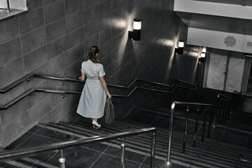 Girl on the stairs down, late transition, subway. One person on the descent into the underpass.