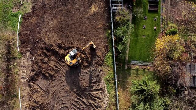Aerial top view on crawler excavator digging ground for overhaul road. Construction machinery performs energy intensive heavy work on project