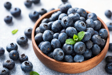 Pile of blueberries in a wooden bowl. Organic juicy blueberries