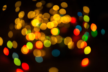 Bokeh on black background for use in photo editor. Beautiful bright curly bokeh. Magic background for new year and Christmas. Banner with multicolored defocused lights garlands in form of circles.