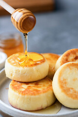 Honey pouring on cottage cheese pancakes fritters Syrniki