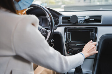 cropped of woman in medical mask adjusting control panel on blurred foreground