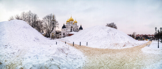 Photo shot of a Large snow hill, a hill, Huge snowdrifts along the paths against the background of an Orthodox Church.
