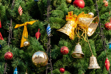 Smartly decorated with bells, bow and balls Christmas tree branches in daylight