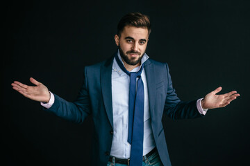 Young man, looking like an entrepreneur, raising his hands, with a questioning or not knowing...