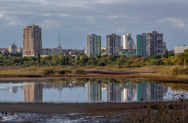 The buildings of the city reflected in the water of Atanasovsko lake.  Burgas, Bulgaria