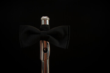 flute in bow tie on black background