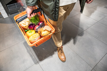 view of man holding grocery basket do shopping