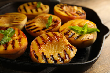 Delicious grilled peaches with mint on table, closeup
