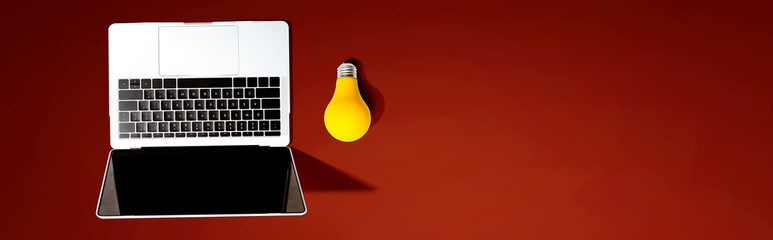 Laptop computer with a yellow light bulb from above