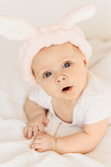 Portrait of adorable baby girl laying on comfortable bed at home, cute little kid enjoy happy childhood, beautiful toddler smiling, childcare concept